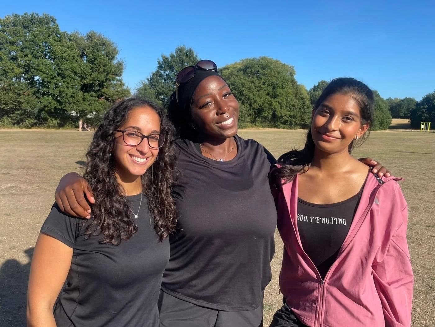The three founders of Escape the Group Chat, arm in arm in a sunny park